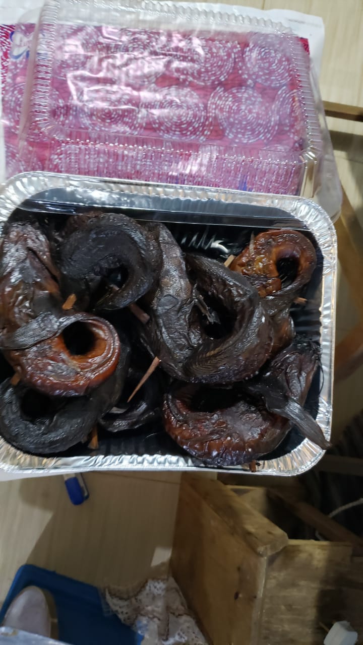 Smoked tilapia hanging in a wood-smoke kiln